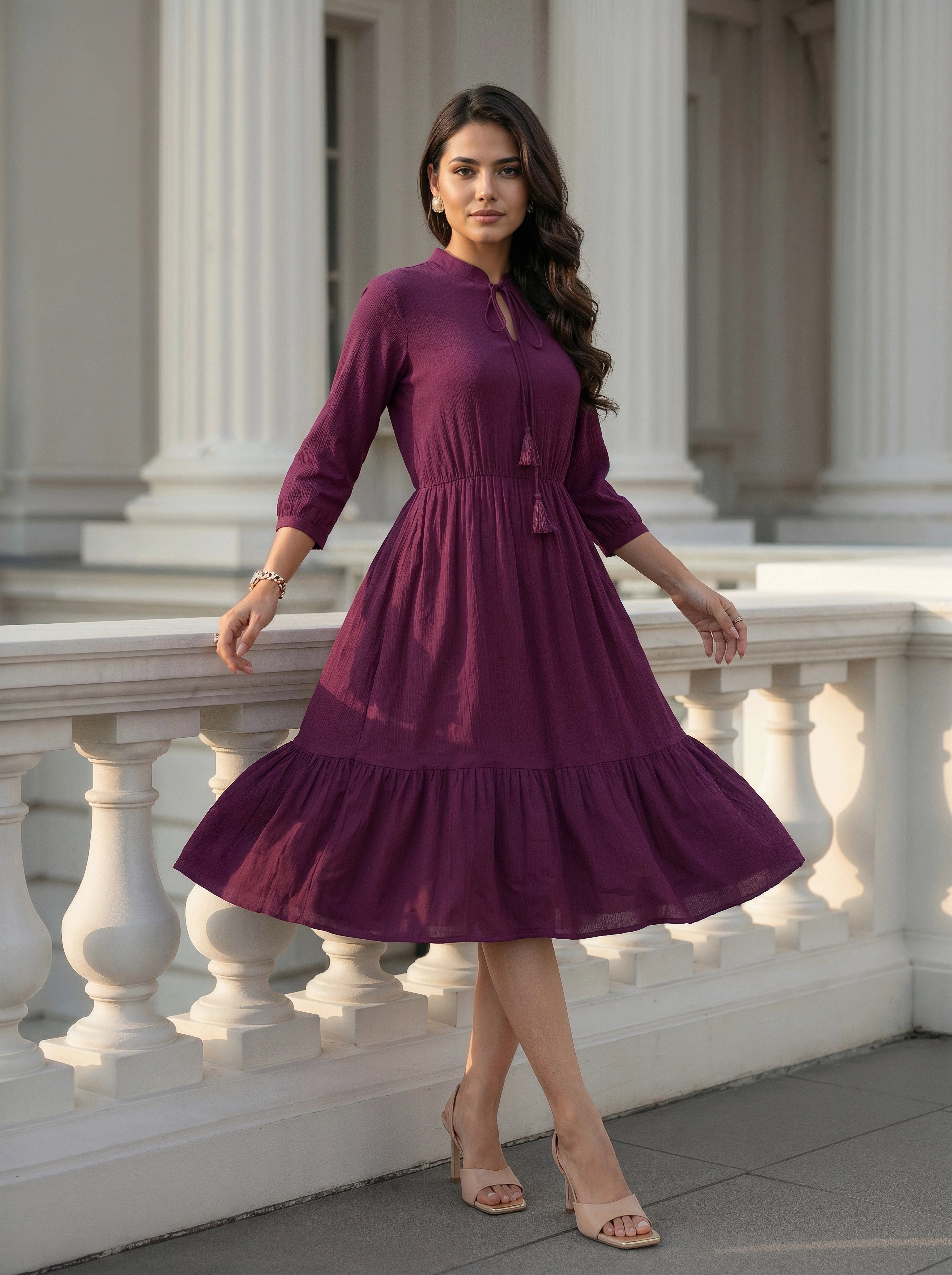Woman in a purple dress standing in front of classical architecture