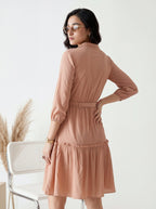 Woman wearing a peach-colored dress with a white background