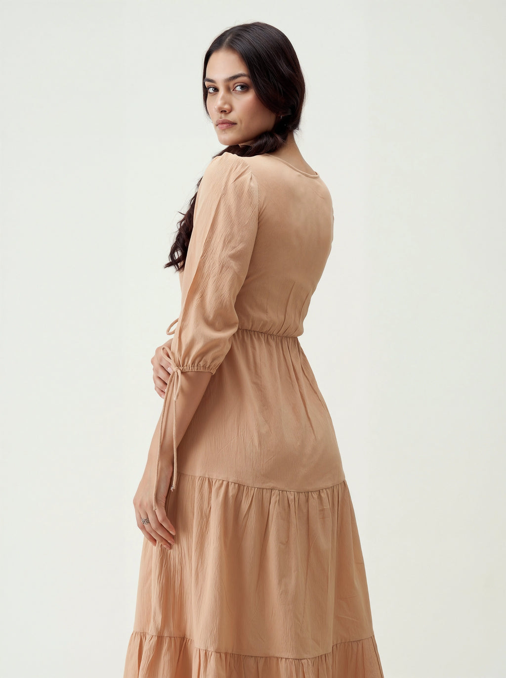 Woman wearing a beige dress on a white background