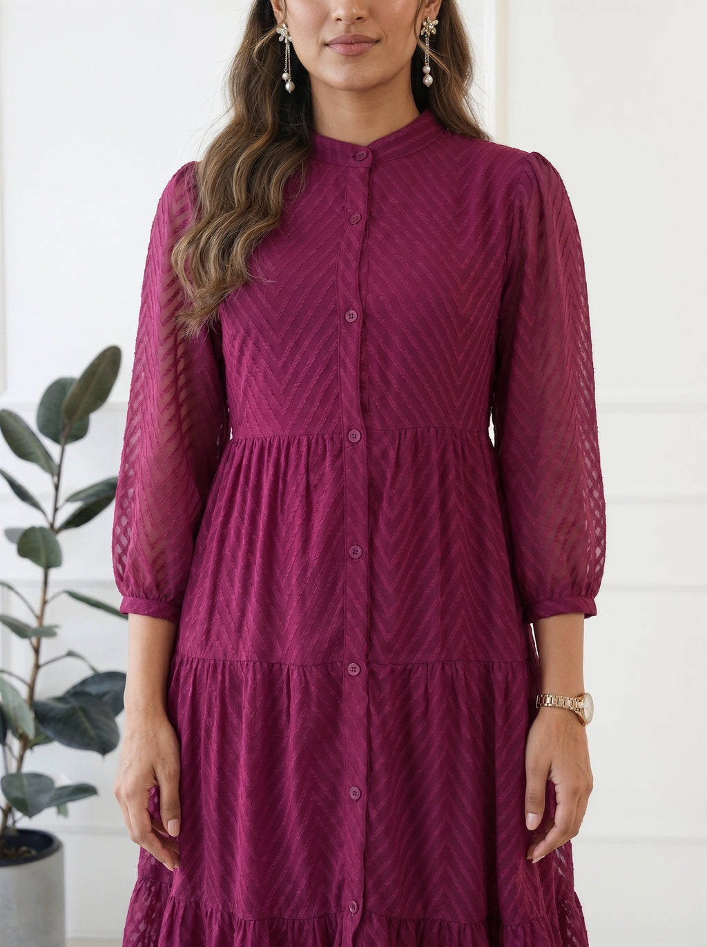 Woman wearing a maroon dress with a white background