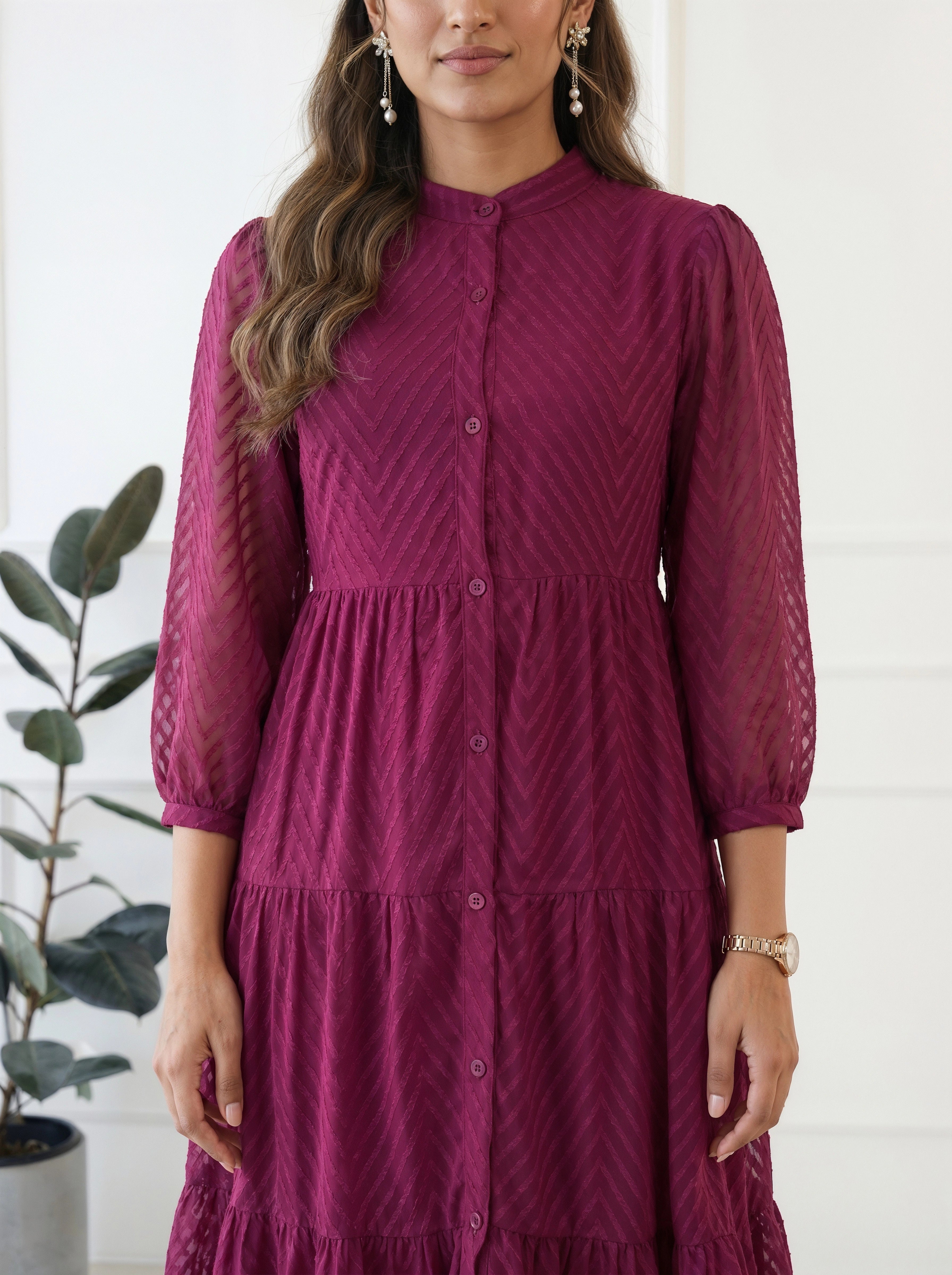 Woman wearing a maroon dress with a white background