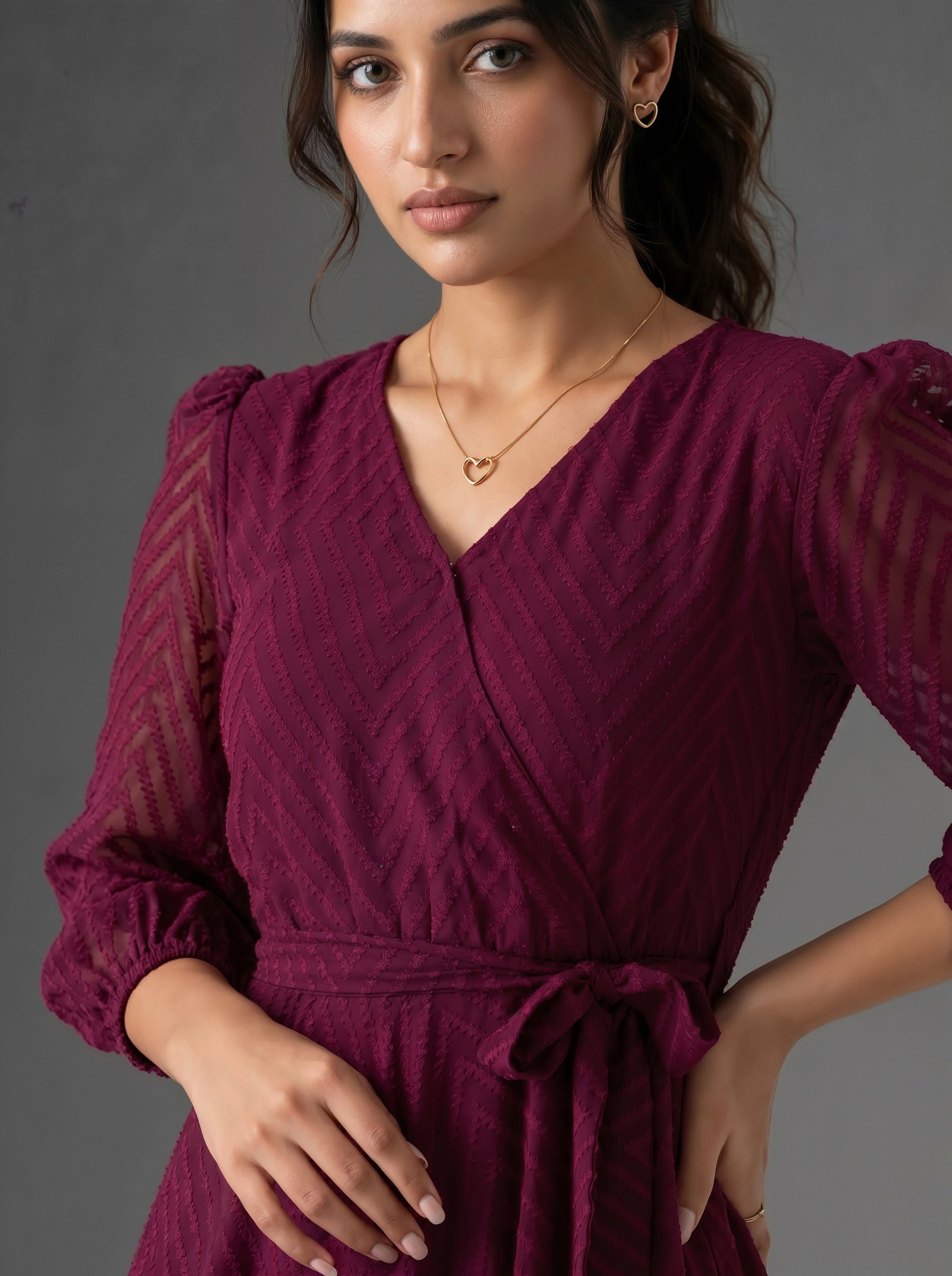 Woman wearing a burgundy dress with a gray background
