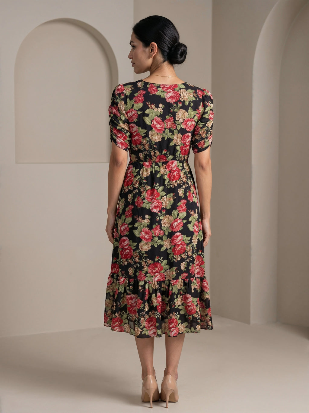 Woman wearing a floral dress in a neutral setting