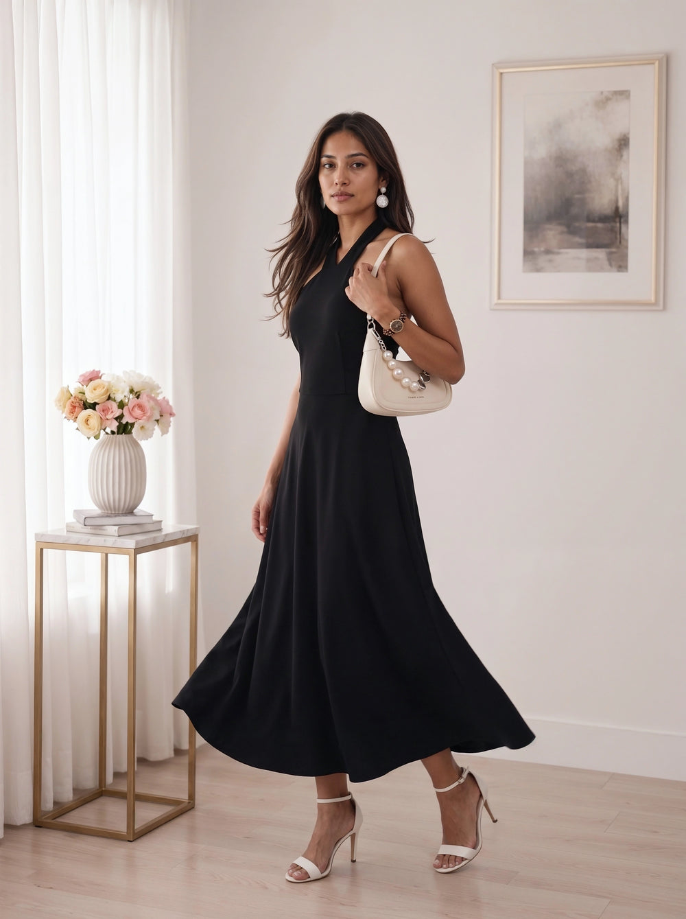 A woman modeling a navy blue tiered mini dress with elbow-length sleeves, paired with white block-heel sandals, standing in a bright room with a wooden floor and a potted plant.