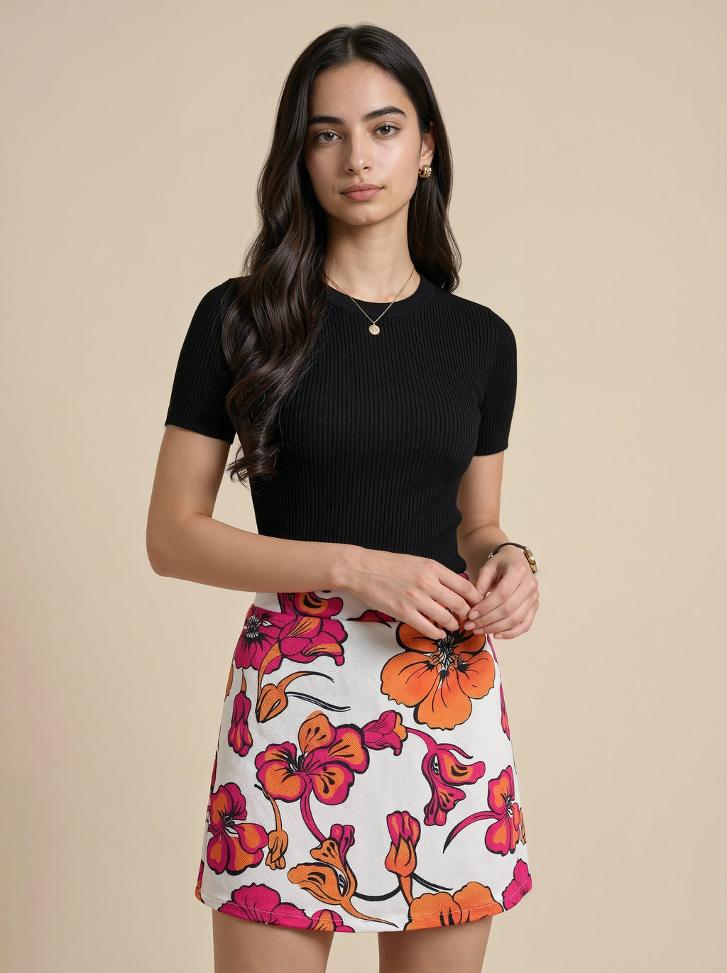 Woman wearing a black top and floral skirt on a beige background