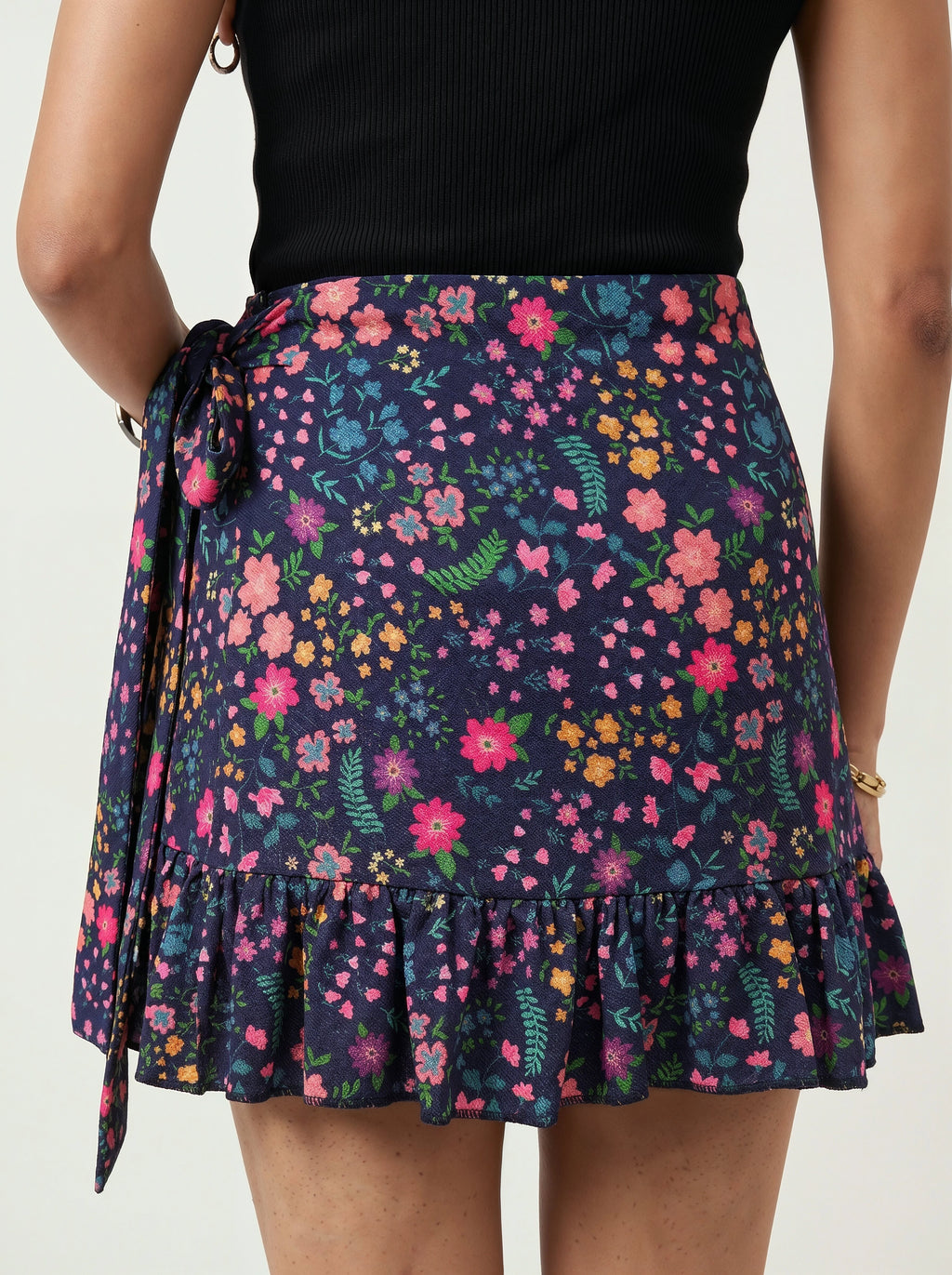 Person wearing a floral skirt with a plain background