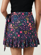 Person wearing a floral skirt with a plain background