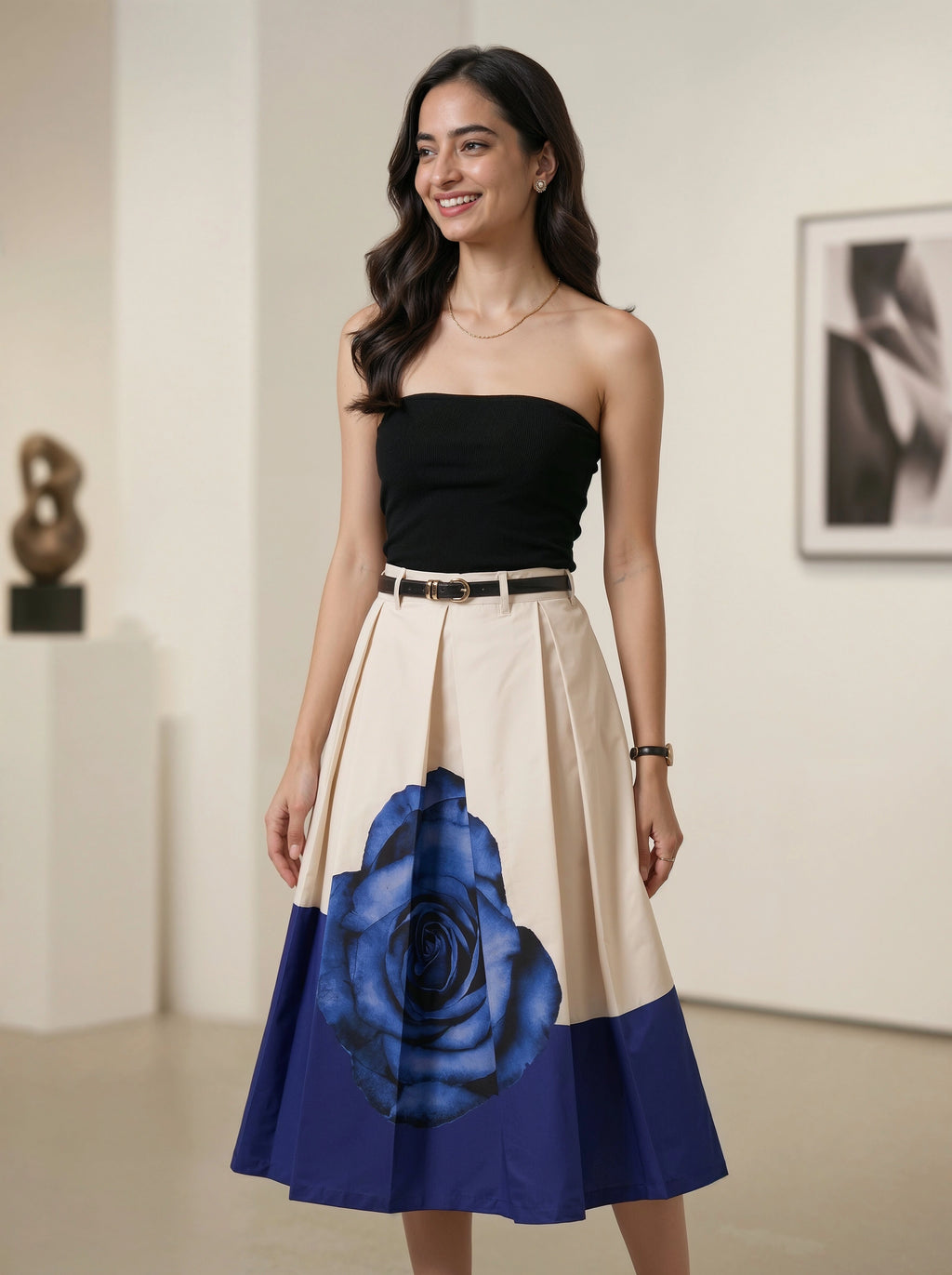 Woman wearing a black strapless top and a dress with a blue rose design in an indoor setting.