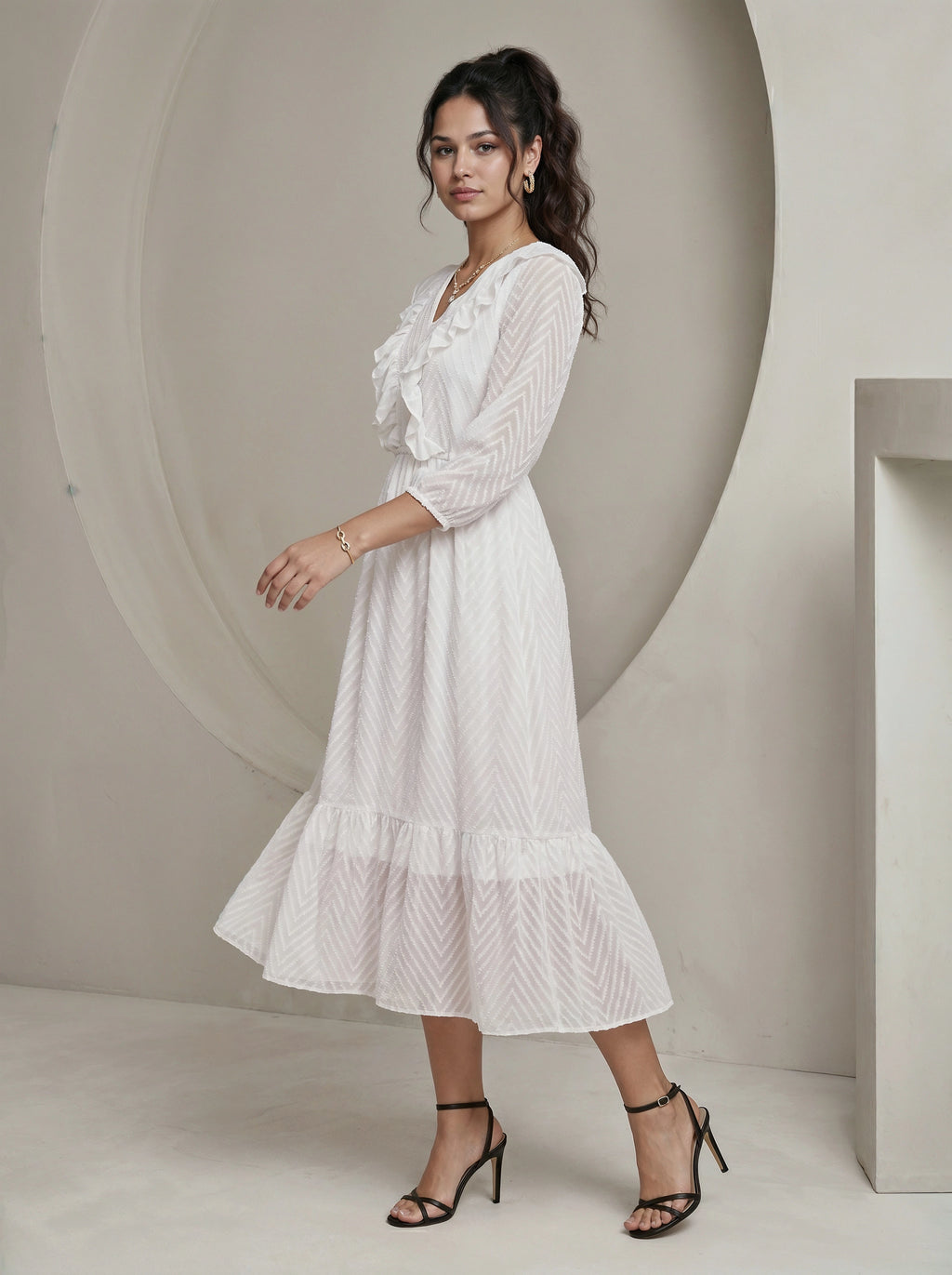Woman wearing a white dress standing against a neutral background