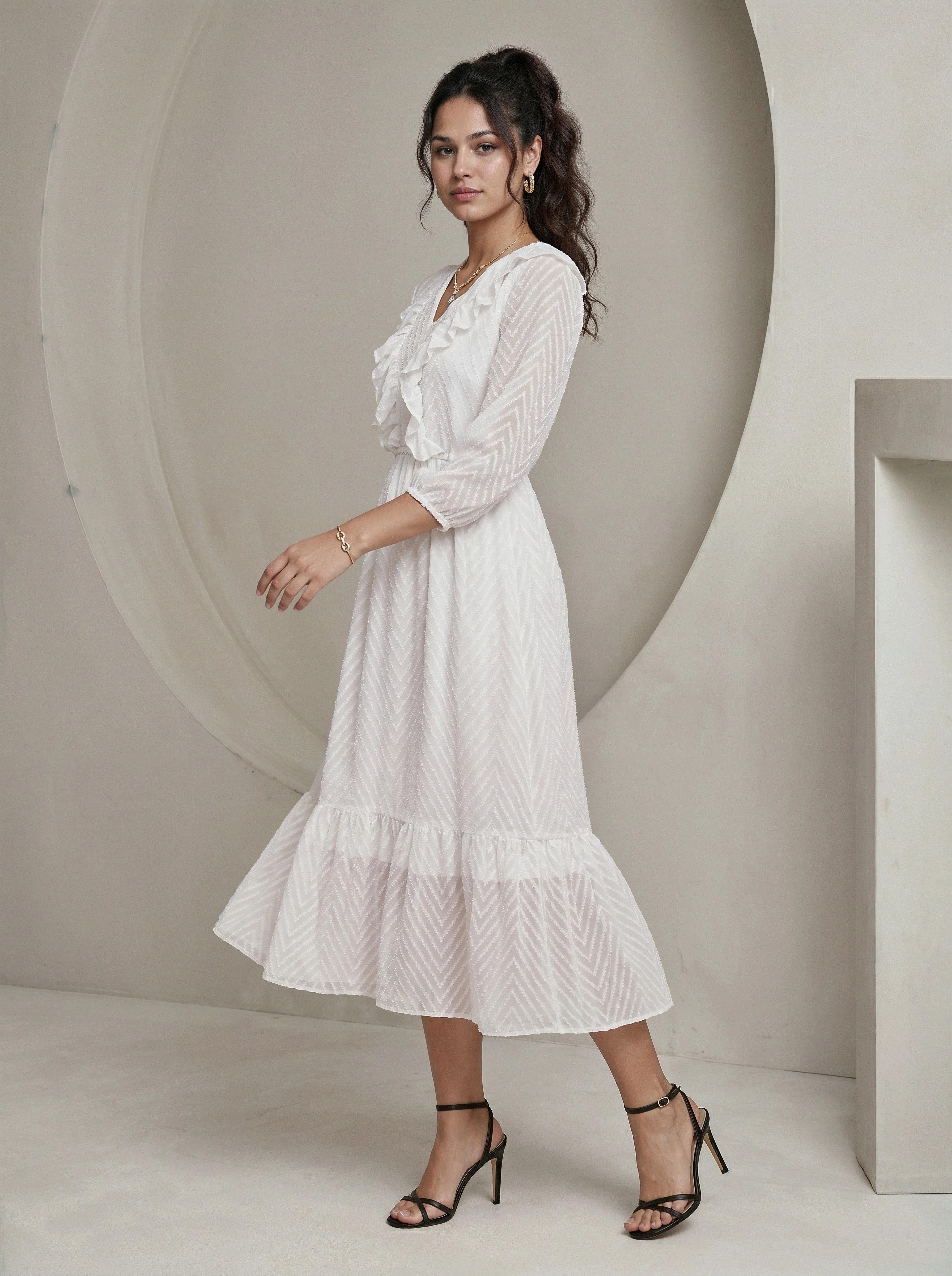 Woman wearing a white dress standing against a neutral background