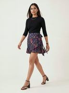 Woman wearing a black top and colorful skirt on a white background