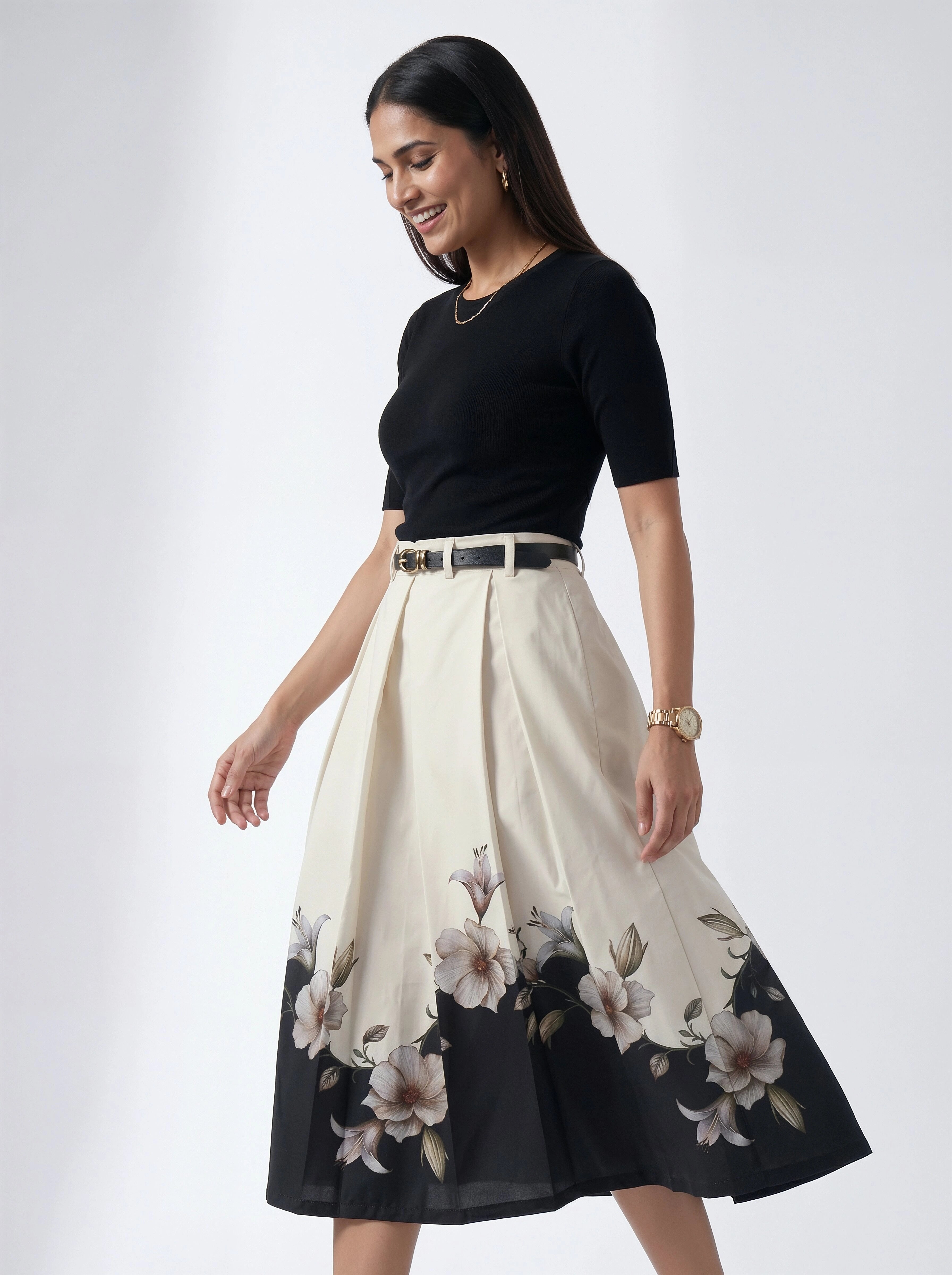 Woman wearing a black top and floral skirt on a white background