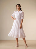 Woman wearing a white lace dress in a minimalistic setting