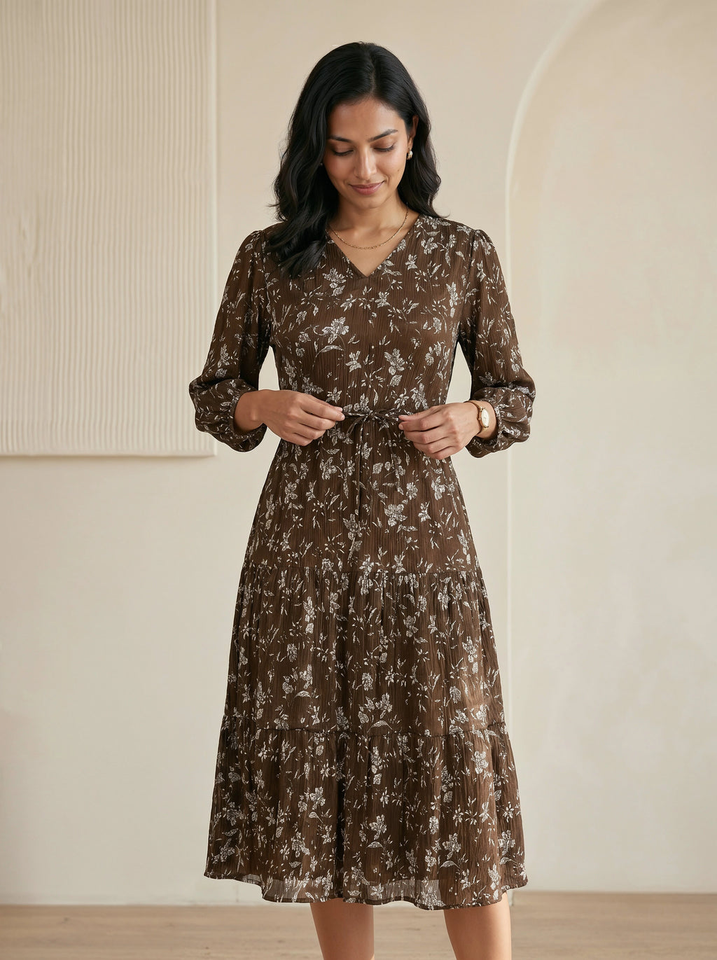 Woman wearing a brown floral dress against a neutral background