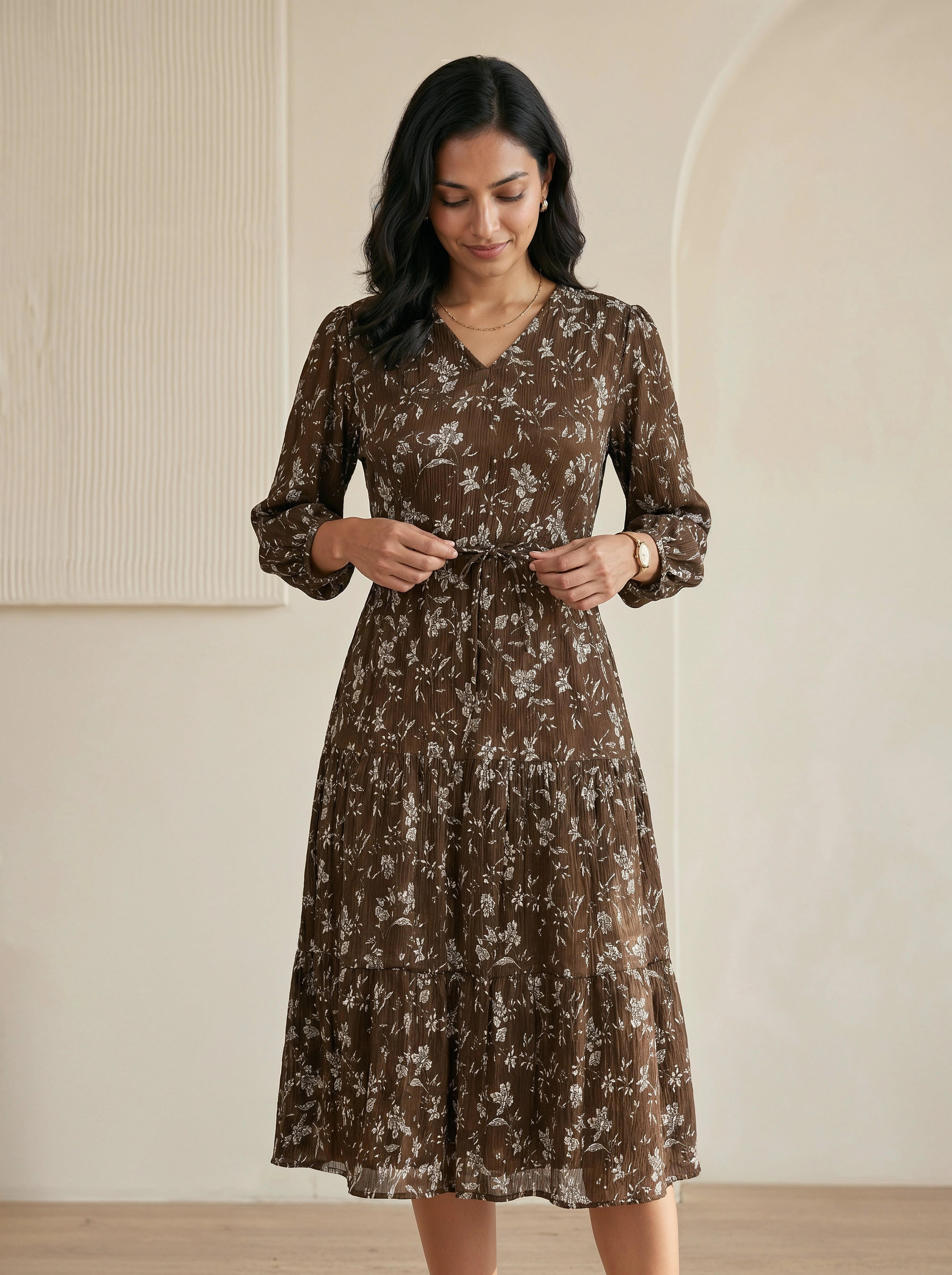 Woman wearing a brown floral dress against a neutral background