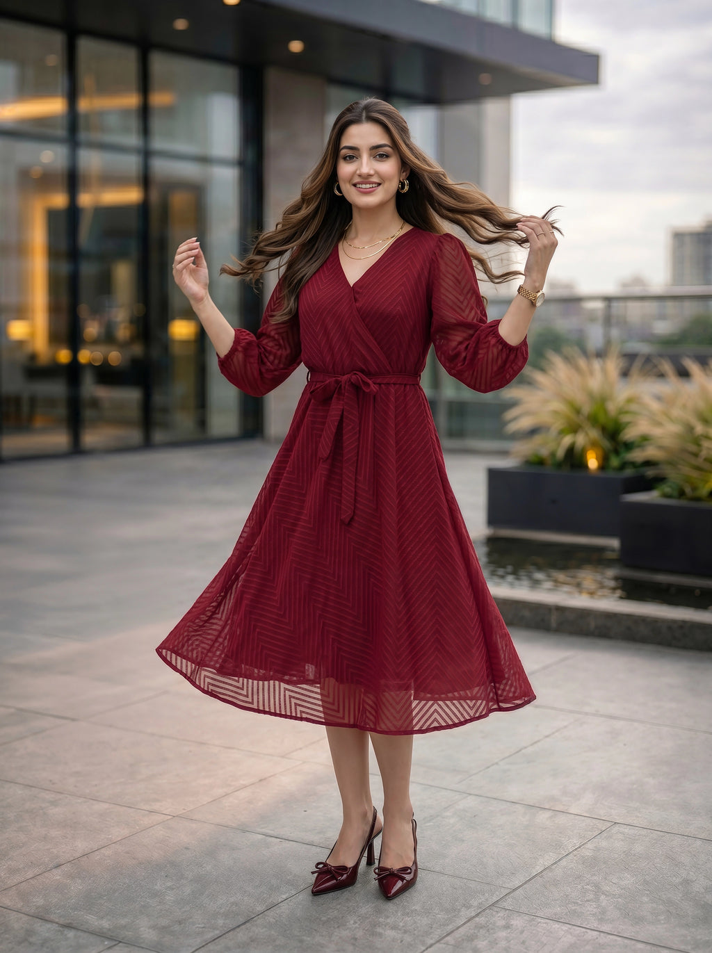 Woman in a red dress standing outdoors with modern building in the background