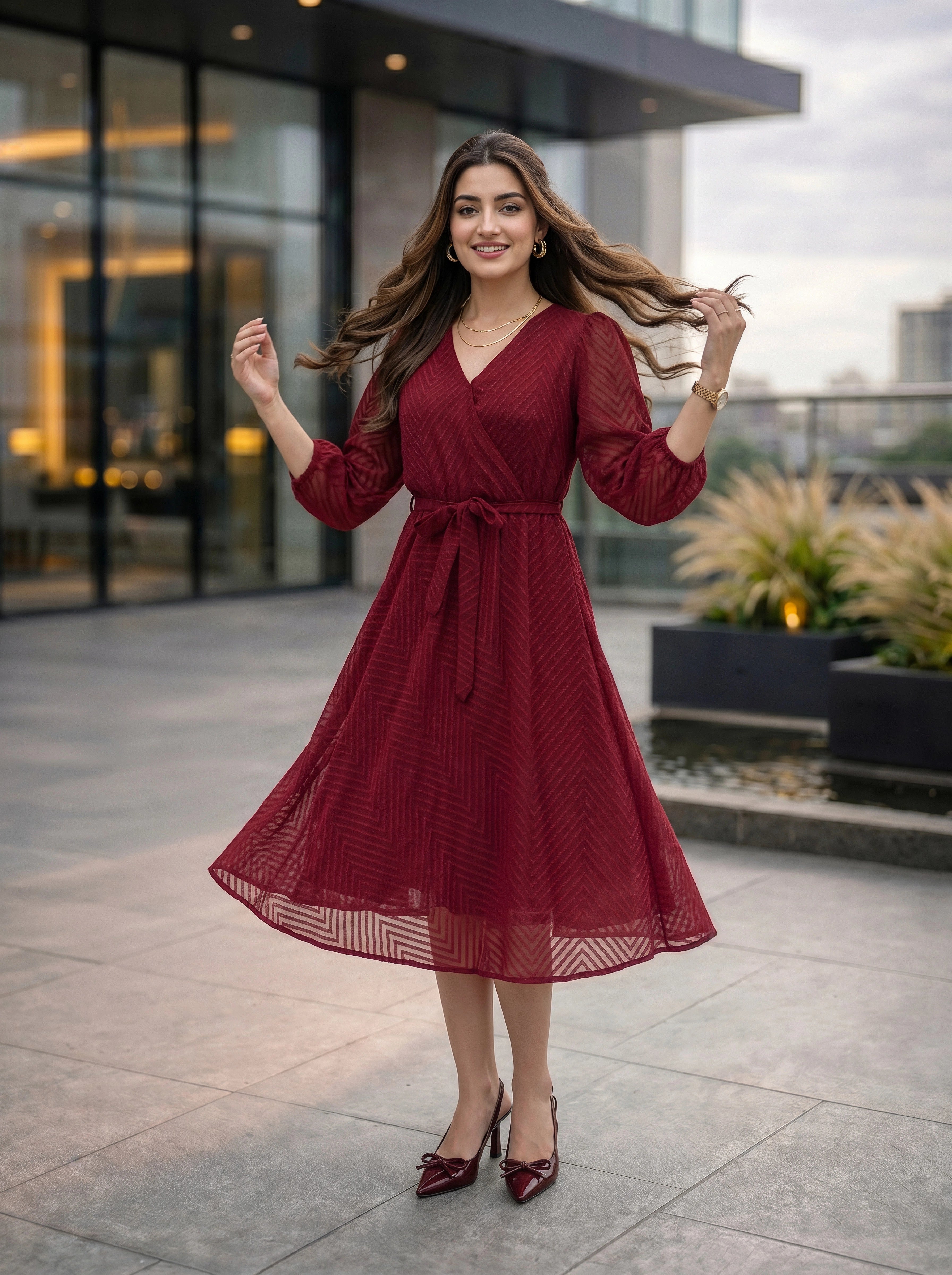 Woman in a red dress standing outdoors with modern building in the background