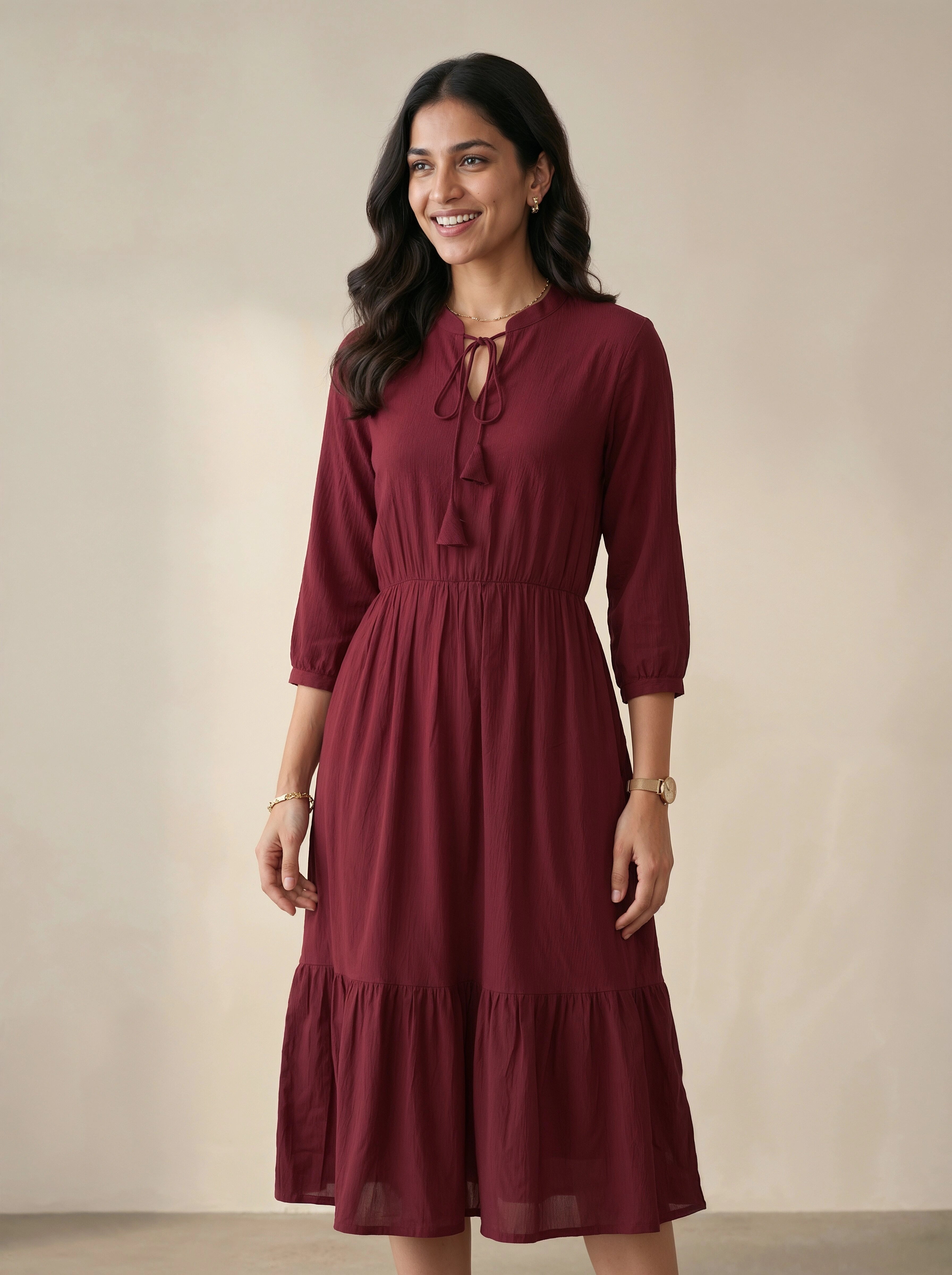 Woman wearing a burgundy dress against a beige background