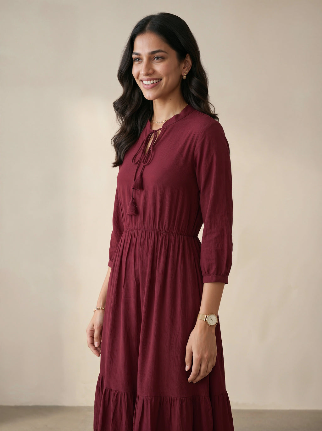 Woman wearing a burgundy dress against a beige background