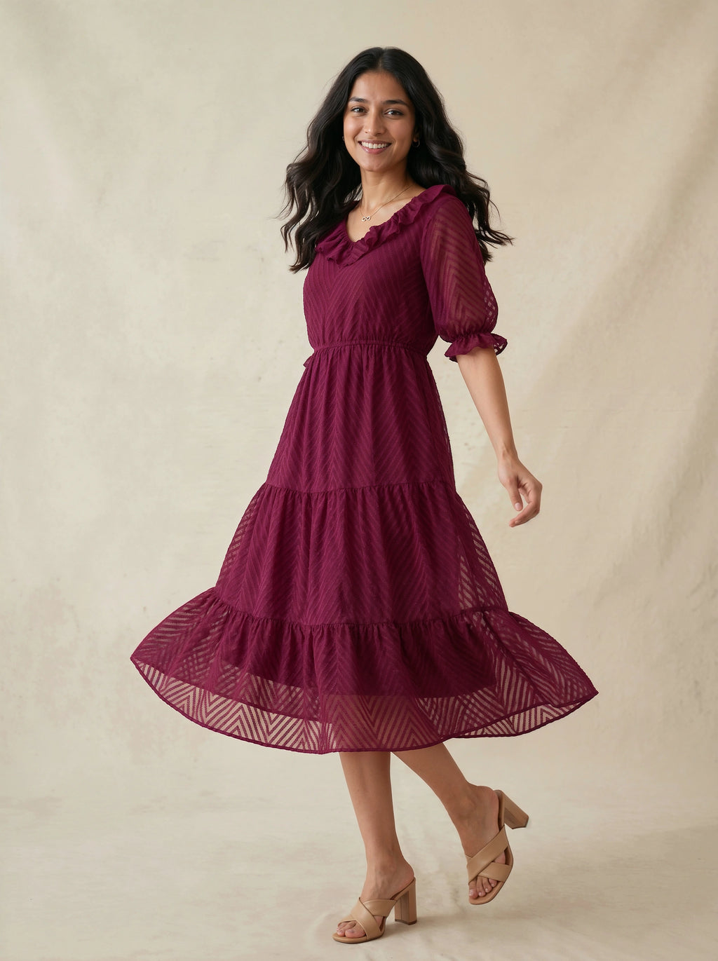 Woman wearing a burgundy dress with puff sleeves against a beige background