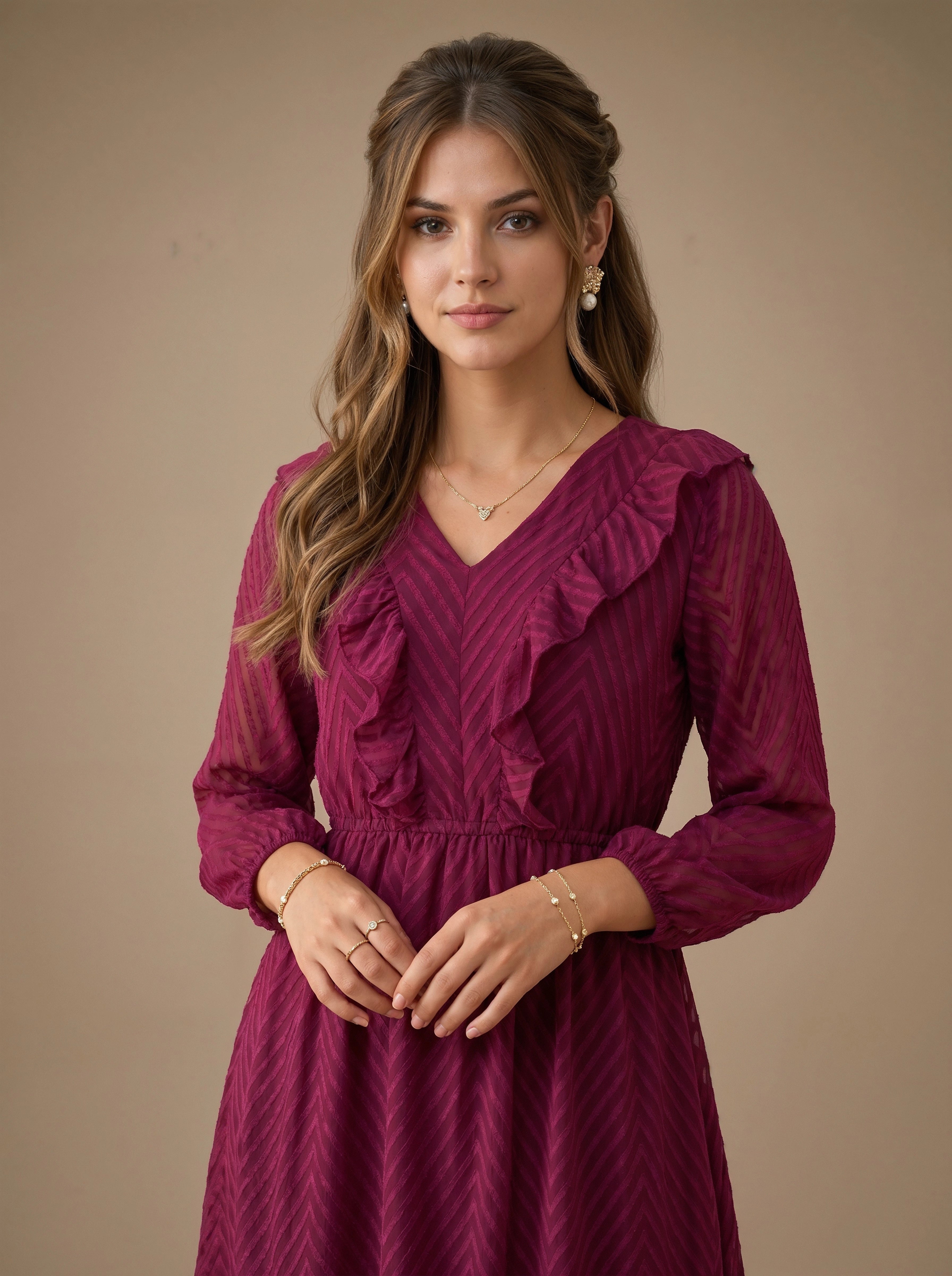 Woman wearing a burgundy dress with ruffled details against a beige background