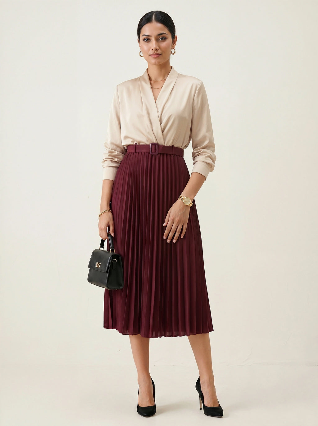 Woman wearing a beige blouse and burgundy pleated skirt with a black handbag on a white background