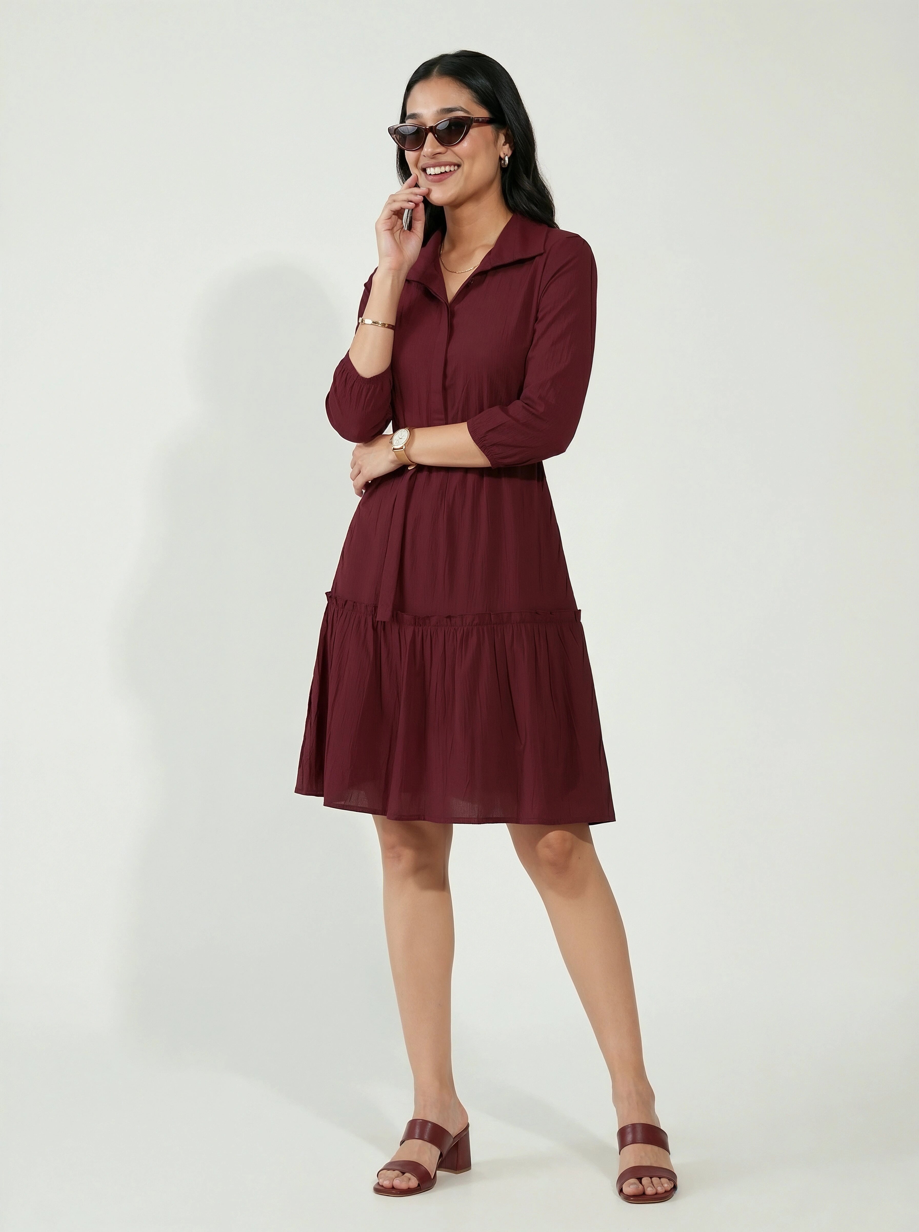 Woman wearing a burgundy dress on a white background