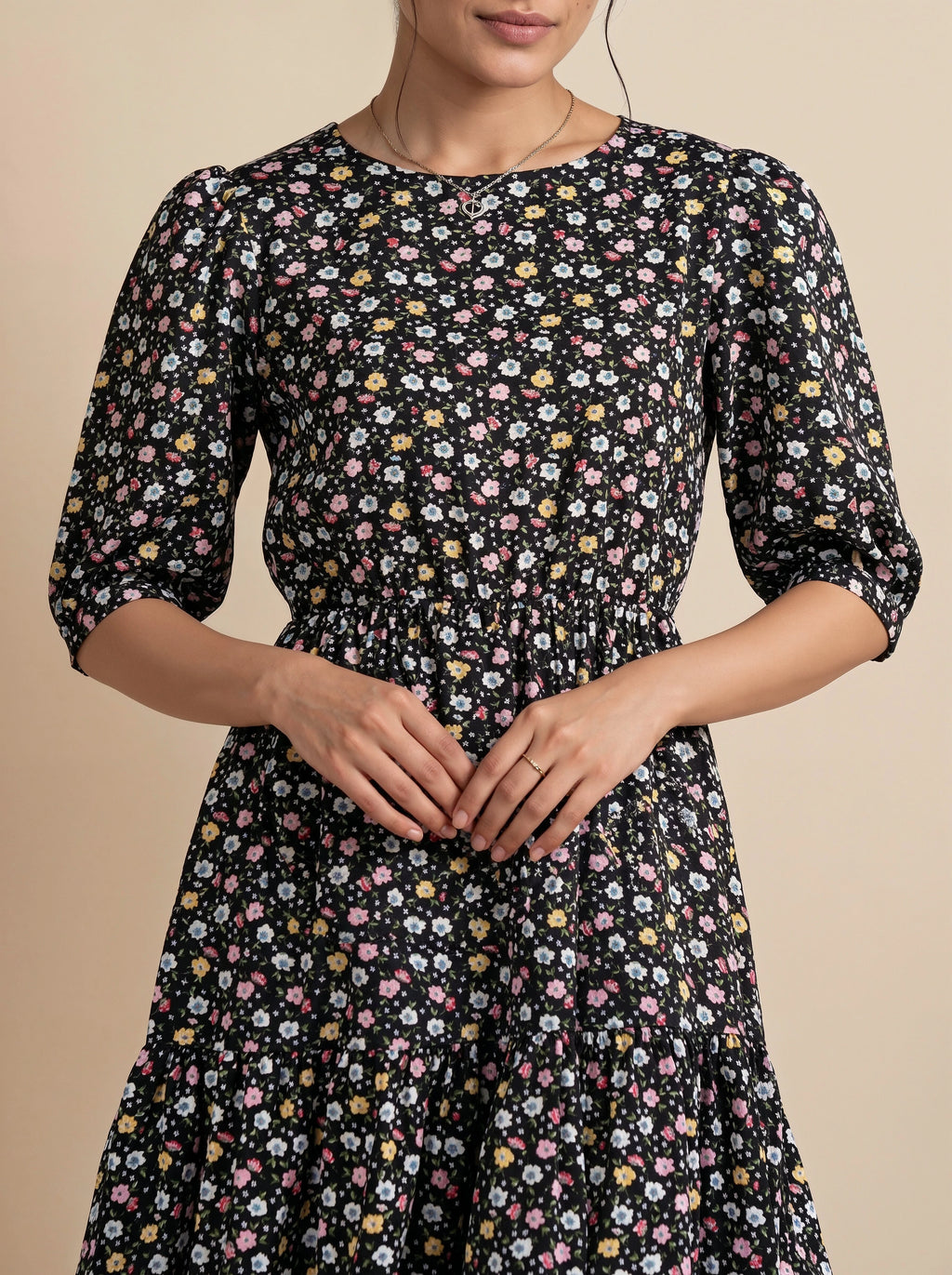 Woman wearing a black floral dress against a beige background
