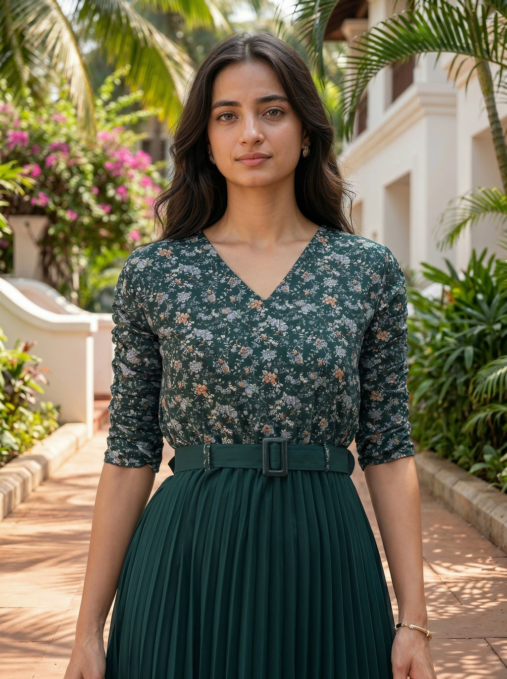 Woman wearing a green floral dress with a belt in an outdoor setting