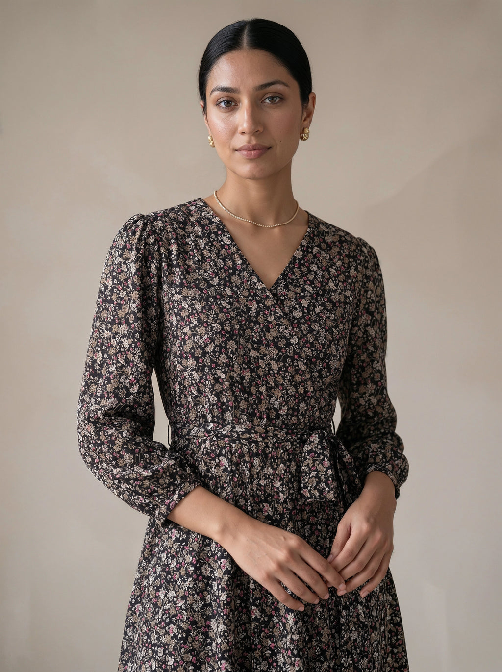 Woman wearing a floral dress against a plain background