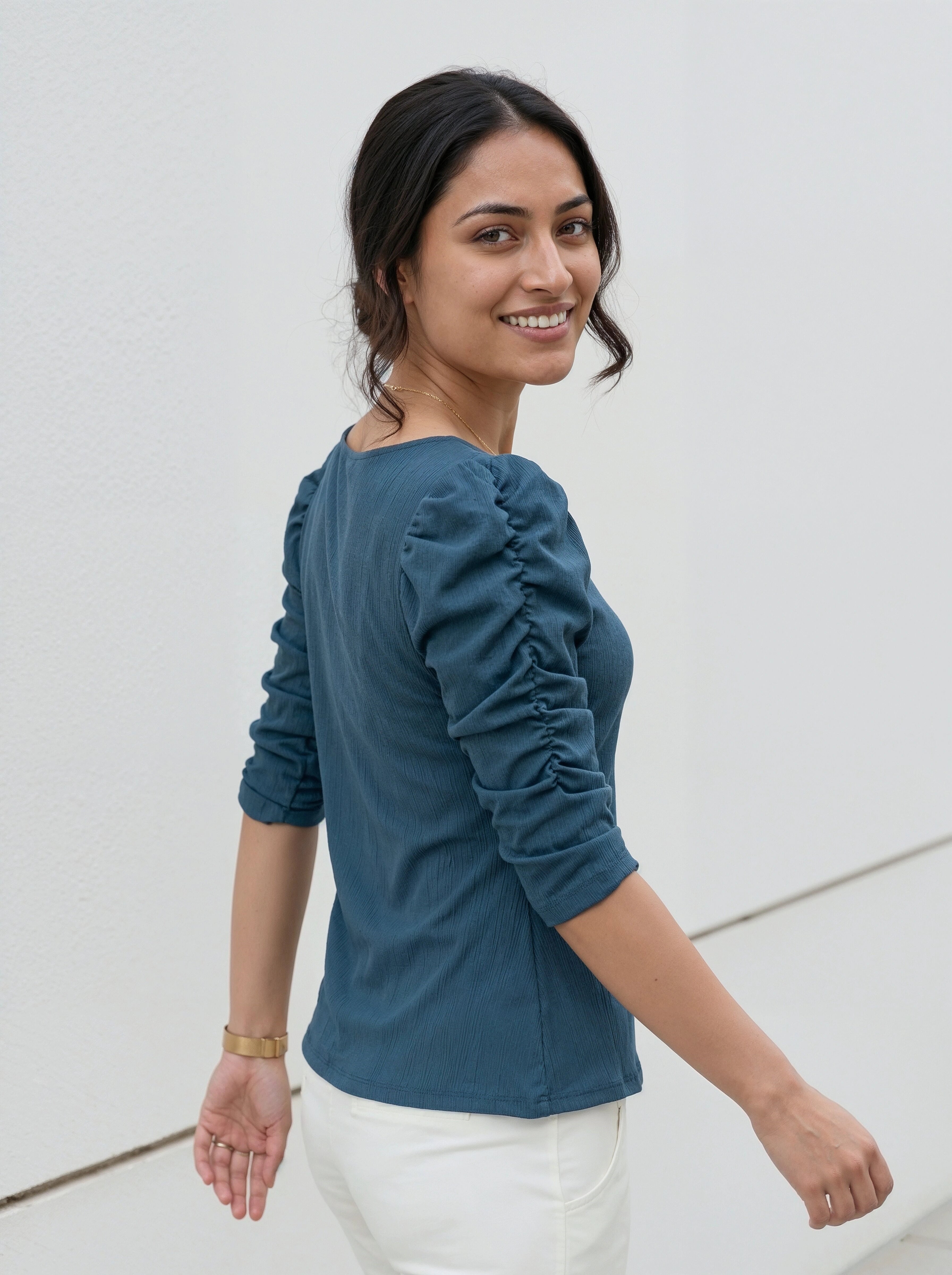 Casual elegant outfit featuring a teal fitted top with voluminous sleeves and white slim-fit pants.