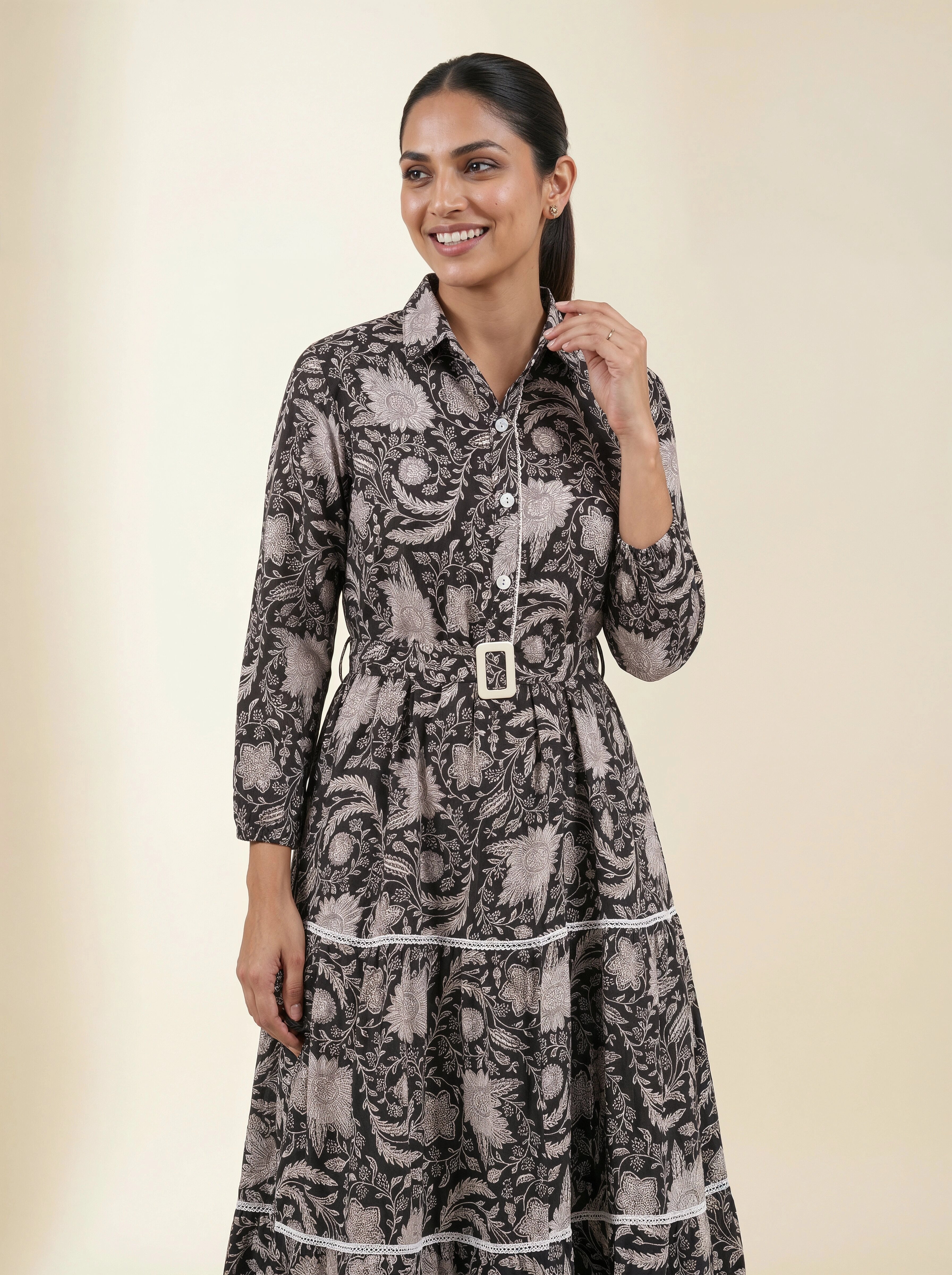 Woman wearing a patterned dress with a belt on a beige background