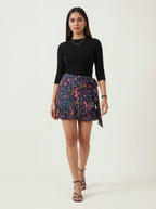 Woman wearing a black top and floral skirt on a white background