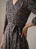 Floral patterned dress worn by a person with a neutral background