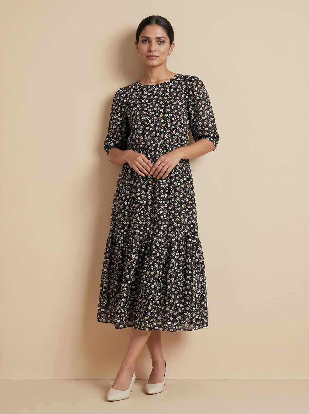Woman wearing a black floral dress against a beige background