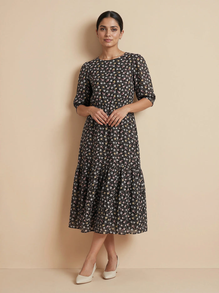 Woman wearing a black floral dress against a beige background