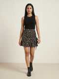 Woman wearing a black sleeveless top and floral skirt on a beige background