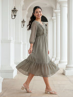 Woman in a green dress standing in a classical architectural setting