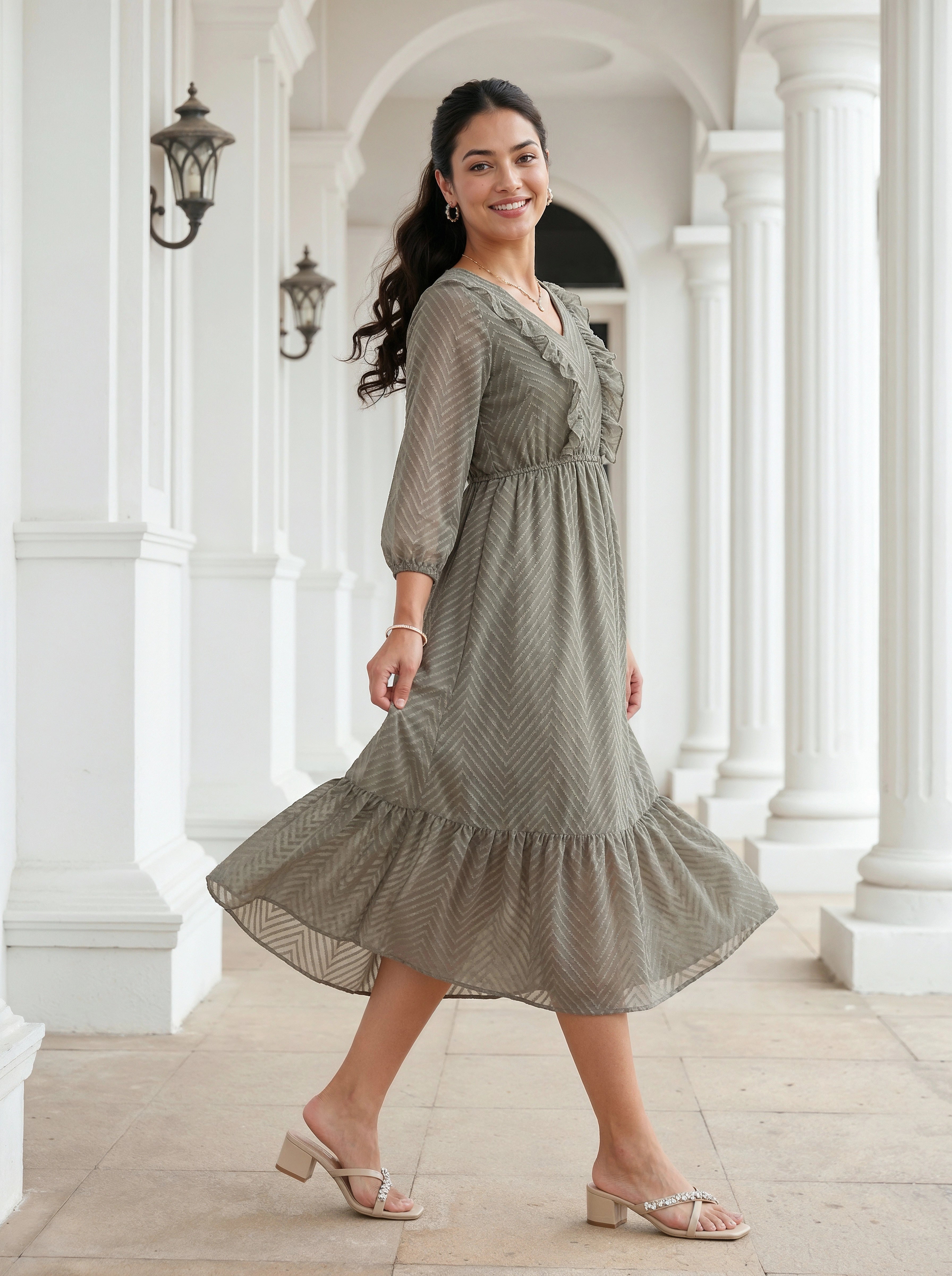 Woman in a green dress standing in a classical architectural setting