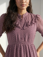 Woman wearing a blue dress standing against a light background