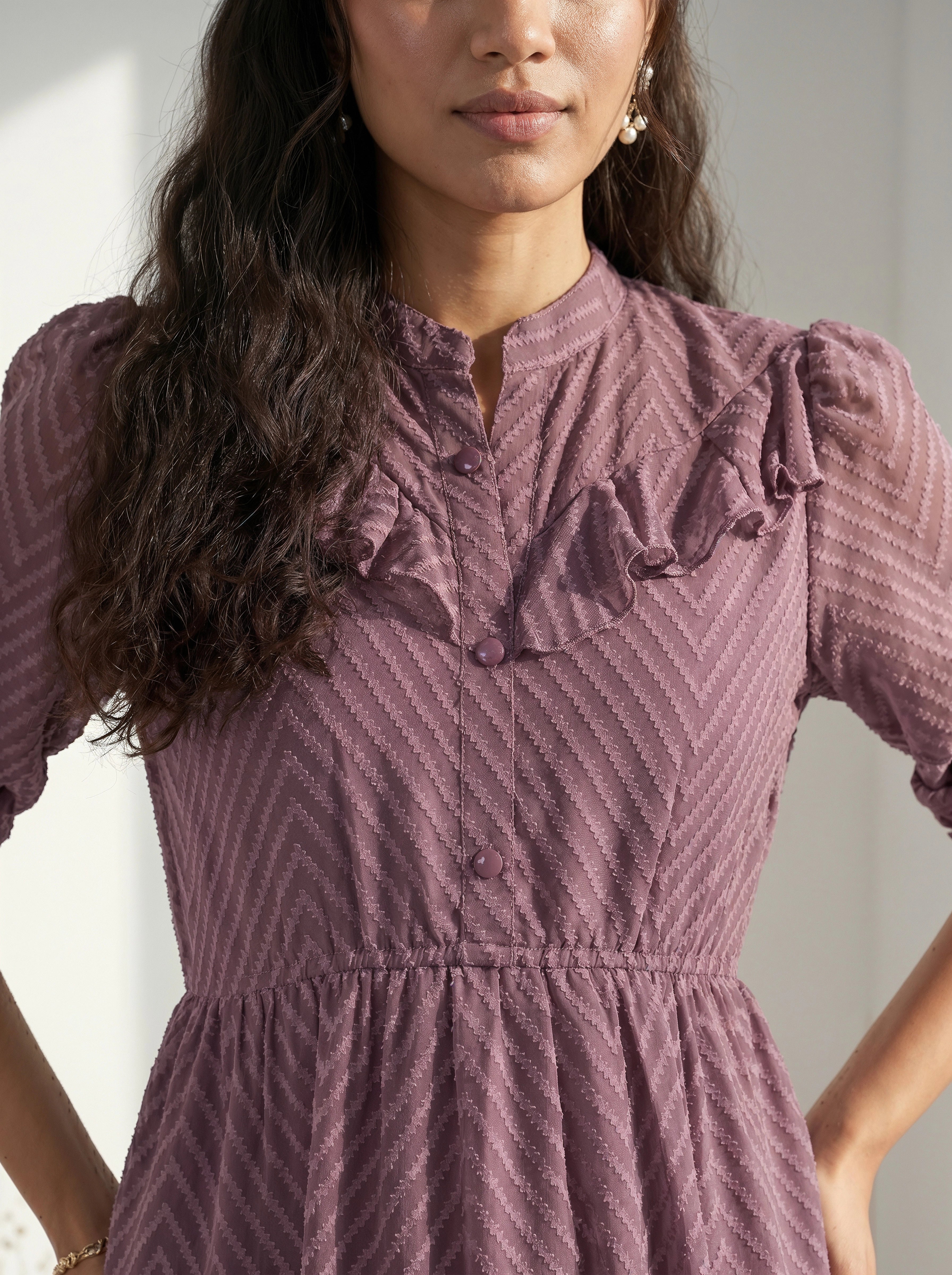 Woman wearing a blue dress standing against a light background