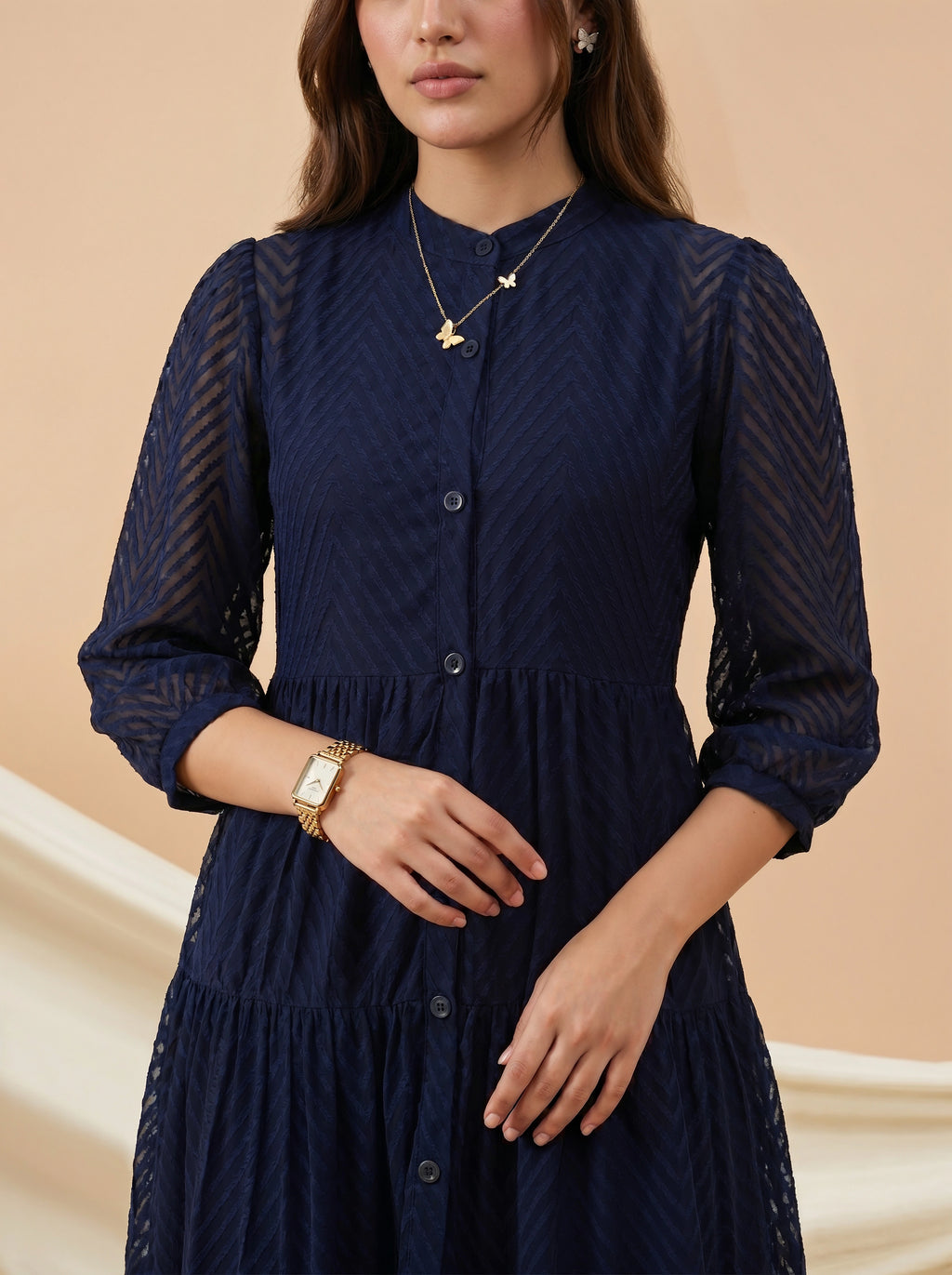Woman wearing a navy blue dress with a beige background
