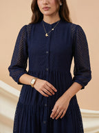 Woman wearing a navy blue dress with a beige background