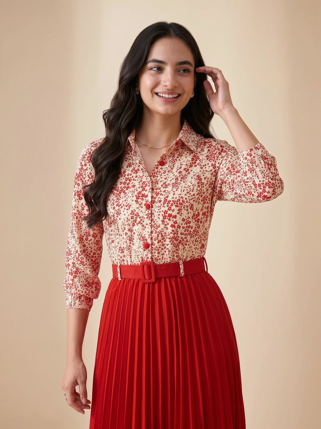 Woman wearing a red and white floral blouse with a red pleated skirt on a beige background