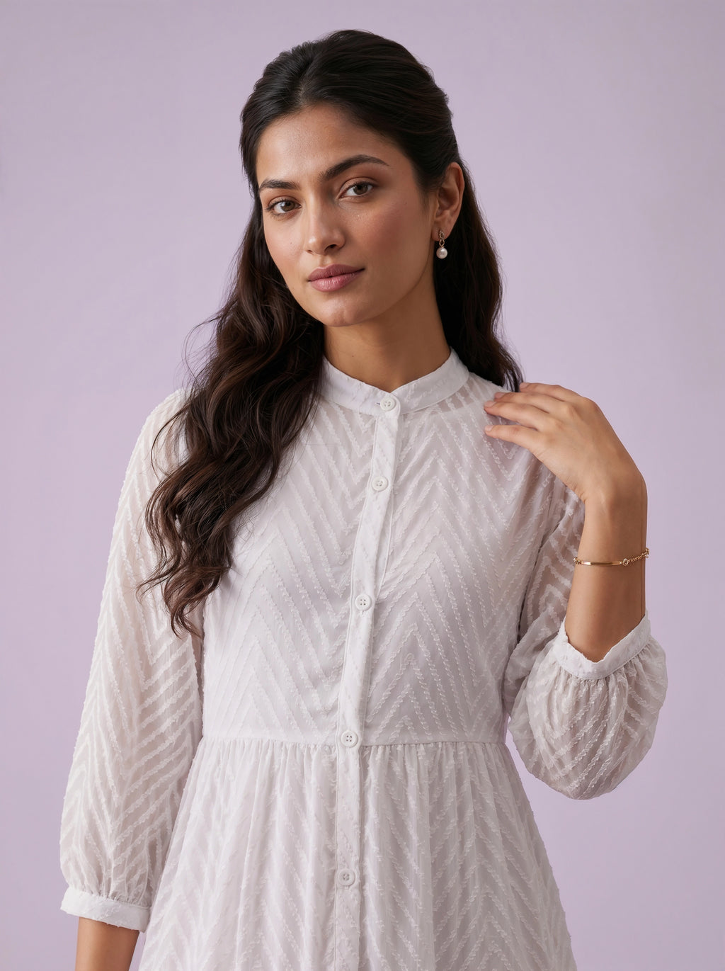 Woman wearing a white textured dress against a light purple background