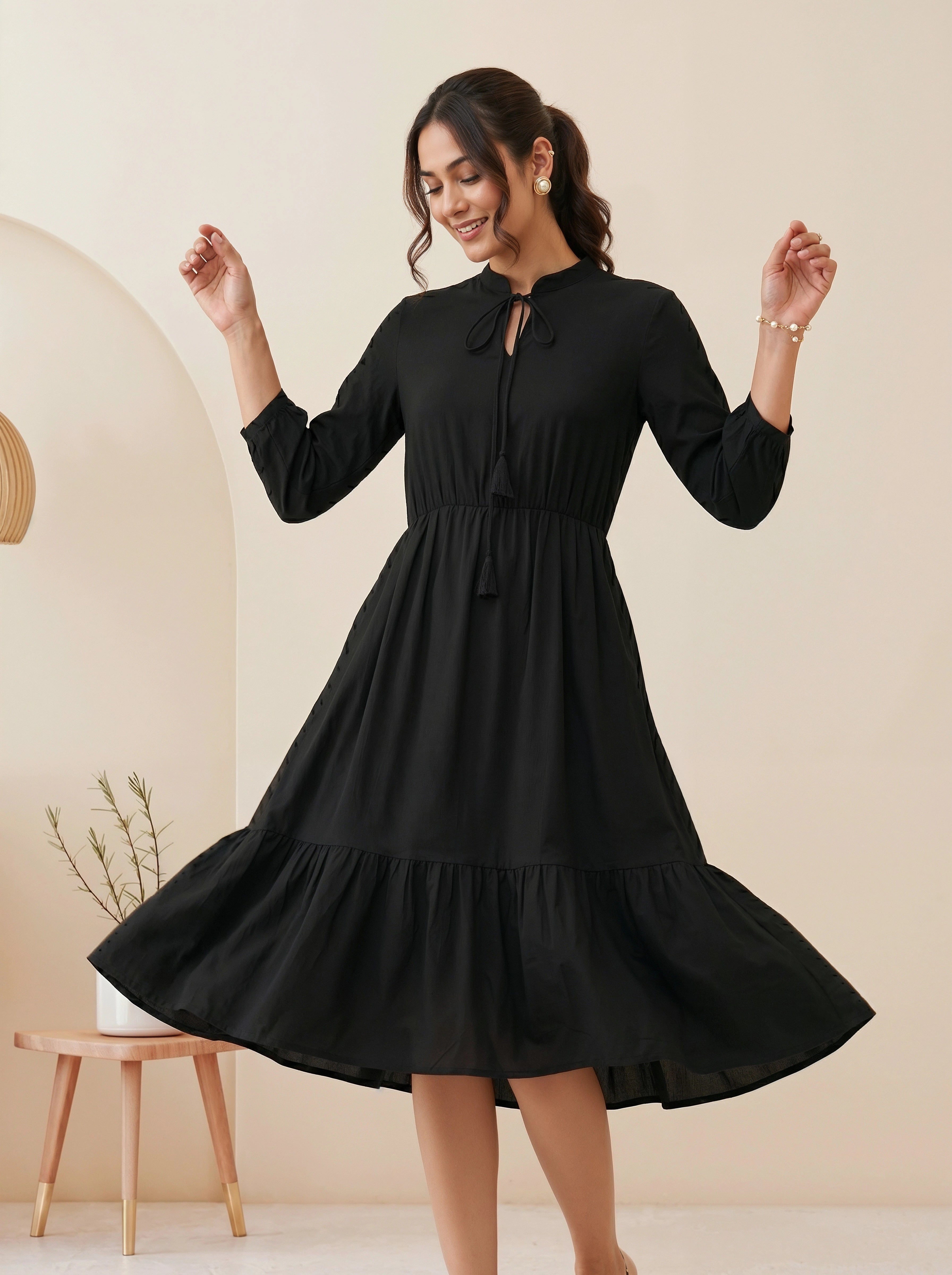 Woman wearing a black dress in a minimalistic setting