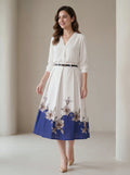 Woman wearing a white dress with floral pattern on a plain background