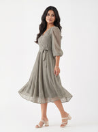 Woman wearing a green patterned dress on a white background
