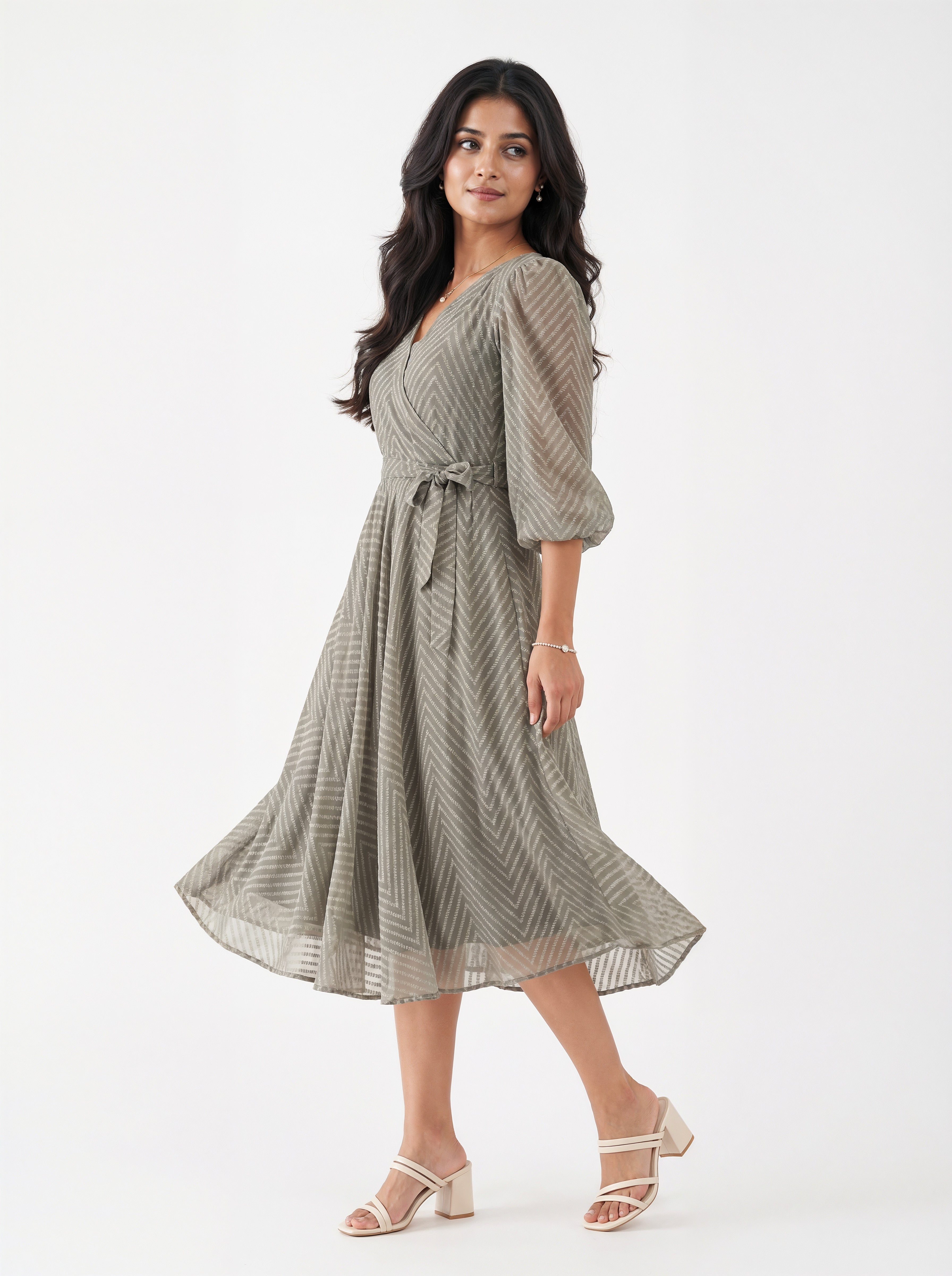Woman wearing a green patterned dress on a white background