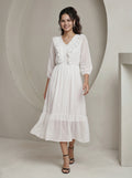 Woman wearing a white lace dress in a minimalistic setting
